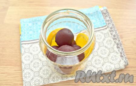 Сливы вместе с ломтиками апельсина перекладываем в простерилизованную банку (я взяла баночку объёмом 1 литр).