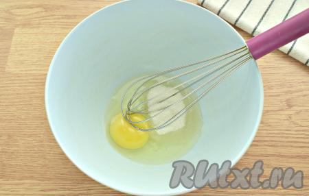 Чтобы творожное тесто получилось мягким, а сами пончики - нежными, творог я рекомендую протереть через сито. Ягоды вишни промываем, удаляем удобным способом косточки. В миску разбиваем яйцо, добавляем сахар. Ручным венчиком ингредиенты взбиваем в течение минуты (до получения однородной смеси).