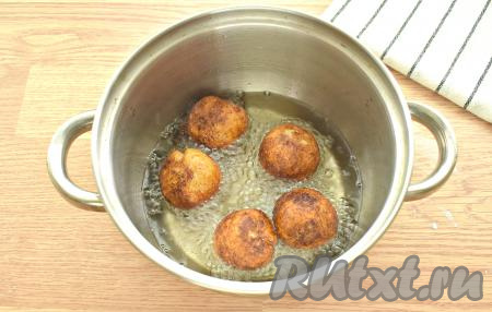 В небольшой кастрюльке разогреваем растительное масло. Выкладываем творожные пончики с вишней в раскалённое масло и жарим их, примерно, в течение 4 минут на среднем огне, переворачивая с одной стороны на другую.