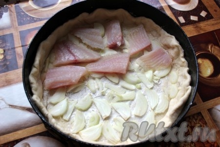 Лук нашинковать крупно и положить в один слой, на который выложить кусочки сырой рыбы.