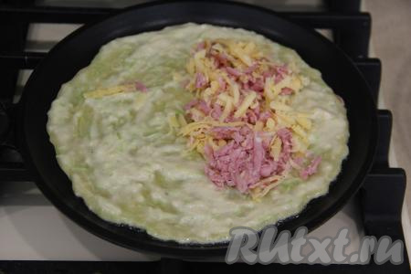 Пока низ кабачкового блина обжаривается, нужно выложить часть начинки ближе к одному краю, немного отступив от этого края. Обычно из указанного количества ингредиентов у меня получается 8 чебуреков, поэтому и начинку я сразу зрительно делю на примерно 8 одинаковых частей.