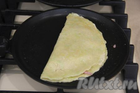 Пока верх кабачкового теста ещё влажный, а низ уже "схватился", свернуть кабачковый блин пополам и прижать лопаткой по всему краю блина, формируя полукруглый чебурек. Края хорошо склеятся.