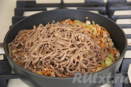 Переложить гречневую лапшу в сковороду к фаршу и овощам.
