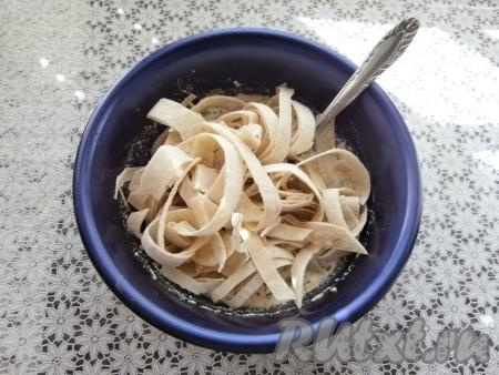 Лаваш свернуть в рулет и нарезать ножницами на полосы шириной около 1 сантиметра. Добавить полоски из лаваша в подготовленную творожно-сырную смесь.