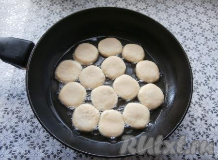 Хорошо разогреть в сковороде растительное масло, выложить заготовки пончиков и жарить их до румяности на среднем огне.