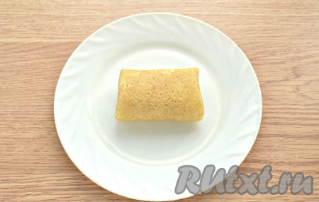 Сворачиваем блин в форме конверта (подворачиваем вначале боковые края блинчика на творожную начинку, а затем сворачиваем блин в рулет, начиная со стороны с творогом). Таким образом готовим и фаршируем все блины. Всего у меня вышло 14 штук, я готовила на сковороде диаметром 18 сантиметров.