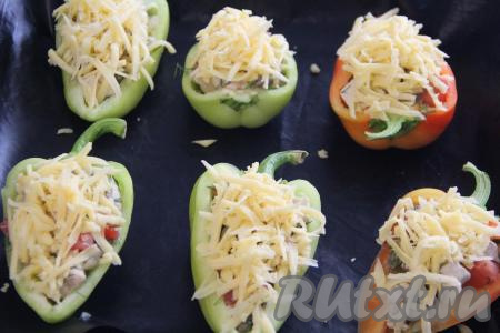 Фаршированные половинки перцев присыпать натёртым сыром.