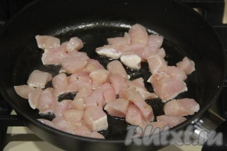 Обжаривать грибы с луком минут 10, иногда перемешивая. Переложить грибы с луком в миску. В сковороду влить ещё немного растительного масла и выложить куриное филе, нарезанное на небольшие кусочки.