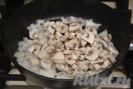 Обжарить лук в течение 5 минут на среднем огне, помешивая. Шампиньоны промыть водой, убирая загрязнения с грибов, затем дать немного обсохнуть и нарезать на пластинки (вместо шампиньонов можно взять вешенки или заранее отваренные в кипящей воде в течение 25-30 минут лесные грибы). Добавить грибы в сковороду к луку.
