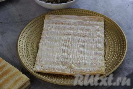 Корж из готового слоёного теста выложить на тарелку и смазать майонезом.