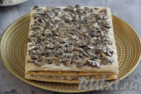 Накрыть начинку следующим коржом и прижать. Смазать корж майонезом и выложить жареные грибы, равномерно распределить, можно слегка посолить.