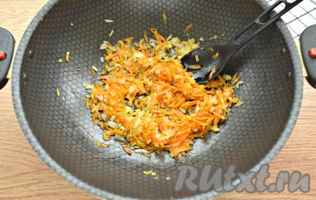 Очищаем морковь, чеснок и луковицу. Кабачок моем. Если шкурка кабачка твердовата, её нужно срезать, крупные семечки тоже нужно удалить. С капусты снимаем верхние листья. Готовить овощное рагу с тушёнкой можно в глубокой сковороде, сотейнике или казане. Я готовила в глубокой сковороде. Разогреваем в сковороде растительное масло, выкладываем морковку, натёртую на крупной тёрке, и достаточно мелко нарезанный лук, перемешиваем овощи и обжариваем их на среднем огне, иногда помешивая, минут 5.