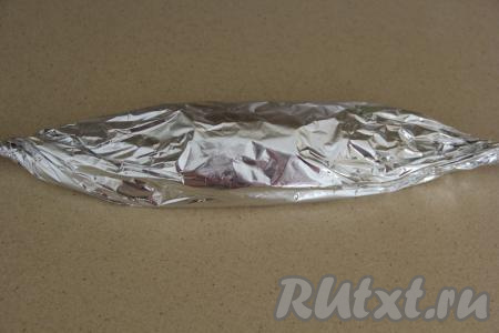 Плотно завернуть скумбрию с лимоном в фольгу и выложить на противень. Запекать скумбрию в фольге в разогретой духовке минут 35 при температуре 180 градусов.