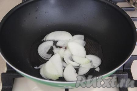 Кабачок для этого блюда желательно брать молодой с мелкими семенами и тонкой шкуркой (если шкурка толстовата - срежьте её). В сковороду с высокими бортиками (я&nbsp;готовила на сковороде вок) влить масло. Почистить луковицу, нарезать полукольцами и выложить в разогревшееся масло.