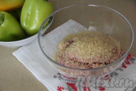 В миску выложить фарш (я приготовила фарш, пропустив через мясорубку кусочки мяса, подойдёт и покупной фарш). Рис промыть, дать стечь воде и переложить к фаршу. Я рис предварительно не отваривала, он прекрасно приготовился в начинке вместе с фаршем.