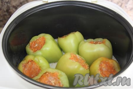 Влить сметанный соус в чашу мультиварки с фаршированными перцами. Закрыть крышку мультиварки и выставить режим "Тушение" на 45 минут.