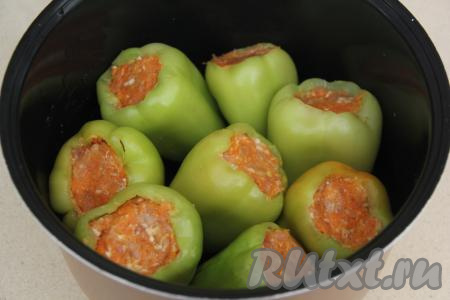 Выложить фаршированные перцы в чашу мультиварки.