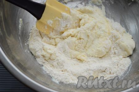 Всыпать муку и вмешать её в творожную массу. Количество муки зависит от размера яйца и от влажности творога. Я добавляю в тесто 2 столовых ложки муки, вмешиваю, тщательно перемешивая творожное тесто лопаткой.