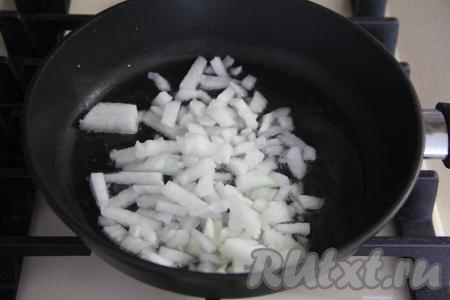 В сковороду влить масло, выложить мелко нарезанную луковицу, обжаривать в течение 2-3 минут, помешивая, на среднем огне.