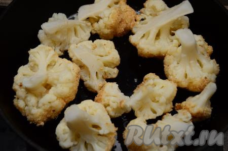 Выложить соцветия цветной капусты, покрытые яцом и сухарями, на разогретую с растительным маслом сковороду, и обжаривать на среднем огне 2 минуты (до румяности).