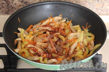 В сковороду со свининой и овощами добавить соль и специи, перемешать.