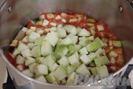 Перемешать массу и поставить на огонь. Кабачки нарезать на кубики размером, примерно, 1,5 сантиметра на 1,5 сантиметра. Как только томатная смесь в кастрюле закипит, добавить в неё кабачки, перемешать, варить с момента закипания на умеренном огне 10 минут, периодически перемешивая.
