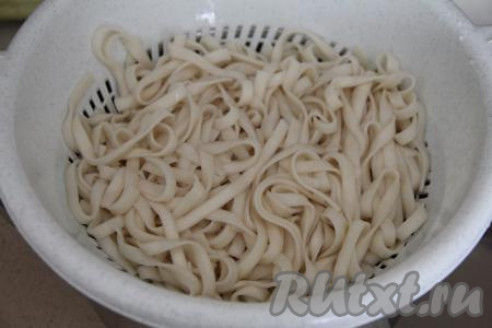 Готовую лапшу откинуть на дуршлаг, промыть холодной водой, дать стечь лишней воде с удона.