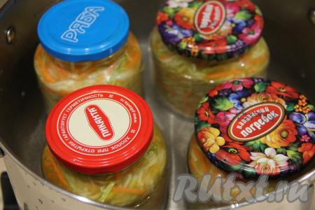 На дно большой кастрюли выложить сложенное в 2-3 раза полотенце, поверх него поставить баночки с корейской закуской из кабачков. Влить в кастрюлю тёплую воду, чтобы она доходила до плечиков банок, и поставить на средний огонь. После того как вода закипит, стерилизовать банки с закуской на небольшом огне минут 15.