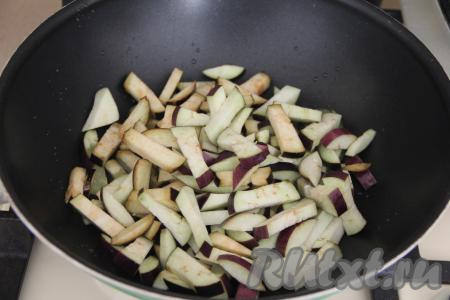 Обжарить кусочки куриного филе в течение 5-7 минут на среднем огне, периодически перемешивая. Обжаренное мясо переложить на тарелку. Можно в ту же сковороду влить немного масла и выложить нарезанные баклажаны, я взяла более большую сковороду, так как жарила курицу в маленькой сковороде.