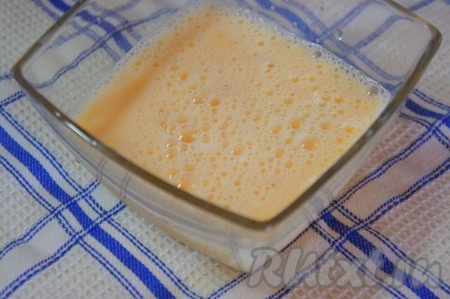 Заранее подготовить заливку для пирога. Для этого яйца взбить вилкой, добавить сахарный песок и молоко, ещё раз взбить. Заливка для сладкого блинного пирога готова.