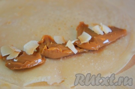 На каждый блинчик выложить немного вареной сгущенки, добавить кокосовые кранчи и свернуть блинчик в "трубочку".