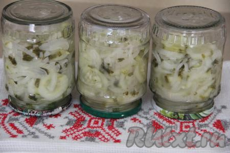 Подготовить большую кастрюлю. Для того чтобы быть уверенным, что банки не лопнут в процессе стерилизации, дно кастрюли можно застелить тканевым полотенцем, сложенным в 2-3 раза. Поставить в кастрюлю банки с огурчиками и луком, влить тёплую воду, которая должна доходить до "плечиков" баночек с салатом. Поставить кастрюлю с баночками на средний огонь, а после закипания стерилизовать салат минут 15 на умеренном огне. Простерилизованные банки с салатом аккуратно достать, закрутить (или закатать) крышками, перевернуть, поставив на крышку. Укутать баночки в одеяло, оставить их до полного остывания, а затем переставить на хранение в прохладное место (я ставлю в кладовку).