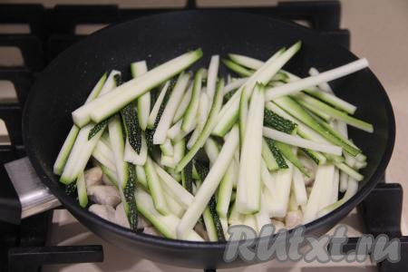 Кабачок нарезать на длинные, тонкие брусочки, а затем выложить в сковороду с обжаренной курицей.