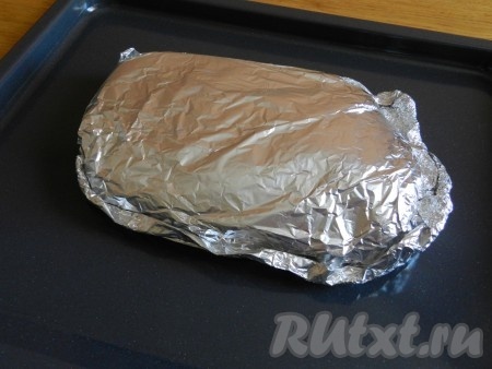 Завернуть мясо в фольгу, тщательно закрепить края фольги, чтобы при запекании не вытекал мясной сок. Для верности можно завернуть мясо ещё в один слой фольги. Свиной окорок, завёрнутый в фольгу, выложить на противень (или в форму для запекания) и отправить в духовку, разогретую до 200 градусов.