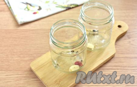 Пока варится сок, можно простерилизовать банки (я стерилизовала их над паром) и крышки (я стерилизовала их 3 минуты после закипания воды). По простерилизованным банкам (я взяла две 0,5-литровые баночки) равномерно распределяем горошинки душистого и чёрного перцев, очищенный чеснок, бутоны гвоздики и колечки жгучего перца.