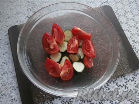 Приготовить маринад, для этого в отдельную пиалу влить растительное масло, добавить уксус, 30 миллилитров воды, всыпать соль и сахар, перемешивать до тех пор, пока соль и сахар не растворятся. В глубокую посуду выкладывать нарезанные дольками помидоры и нарезанные кружками огурцы слоями.