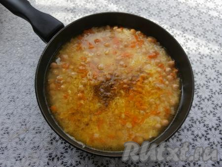 Рис с овощами и нутом перемешать, влить 3 стакана горячей воды (воду нужно отмерять тем же стаканом, которым вы отмеряли рис), добавить соль, специи, карри, чёрный молотый перец и куркуму, перемешать.