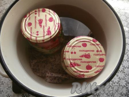 Банки прикрыть прокипячёнными крышками (заранее кипятим крышки 2-3 минуты с момента закипания воды). Дно большой кастрюли застелить тряпочкой (или полотенцем), сложенной в 2-3 раза. В эту кастрюлю поверх тряпочки (или полотенца) поставить банки с помидорами, влить горячую воду, которая должна доходить до "плечиков" баночек. Поставить кастрюлю с банками на средний огонь, после закипания воды стерилизовать литровые баночки с помидорами и хреном на небольшом огне 15-20 минут.