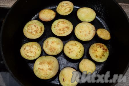 По прошествии 30-40 минут обжарить баклажаны, для этого их нужно выкладывать в один слой на сковороду, прогретую с небольшим количеством подсолнечного масла, и обжаривать на умеренном огне с двух сторон до мягкости и подрумянивания (буквально по 2 минуты с каждой стороны).