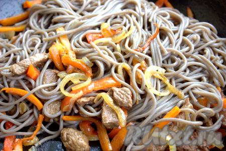 Далее в сковороду к луку, моркови и перцу с говядиной выложить гречневую лапшу. Для любителей поострее можно добавить мелко нарезанный жгучий перчик. Гречневую лапшу с овощами перемешать и прогреть на среднем огне в сковороде минуты 3, не забывая помешивать.