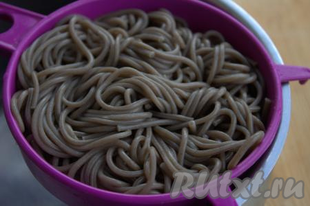 Готовую гречневую лапшу откинуть на дуршлаг, чтобы стекла лишняя вода.