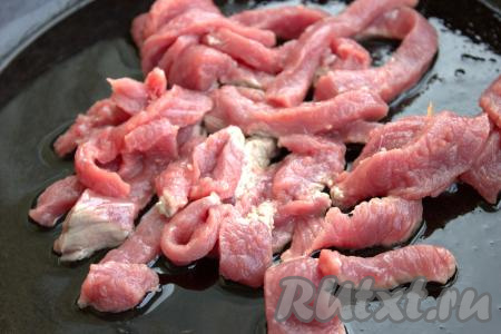 В сковороде с толстым дном (можно взять сковороду вок) разогреть растительное масло, затем выложить нарезанную говядину. Обжаривать мясо на достаточно сильном огне, помешивая, в течение 5-7 минут.