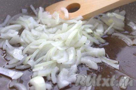 В отдельную сковороду влить 2 столовые ложки растительного масла, немного прогреть, затем выложить лук и обжаривать его, иногда помешивая, до прозрачности (4-5 минут) на среднем огне.