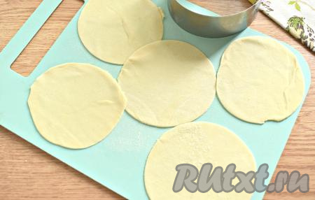 Тесто достаём из холодильника. Делим его на 3-4 куска. Затем вначале один кусок теста на припылённой мукой поверхности раскатываем в тонкий пласт (толщиной 2 миллиметра), из которого вырезаем круглые заготовки для мантов. Я вырезала кружки с помощью кулинарного кольца диметром 10 сантиметров. Аналогично раскатываем и вырезаем кружки из оставшихся кусков теста.