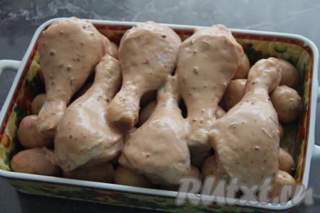 Поверх картошки выложить куриные ножки.