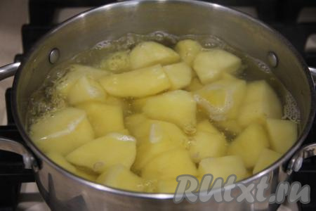 Картошку почистить, нарезать на части, выложить в объёмную кастрюлю, полностью залить картошины водой, затем поставить на огонь и варить после закипания на небольшом огне до готовности картофеля (минут 20-25, картошка должна легко прокалываться ножом).