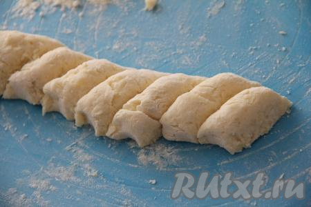 Перемешать картофельно-творожное тесто, оно должно получиться пластичным, не липнущим и нежным (не переборщите с мукой), сформировать из него колбаску и нарезать на кусочки.