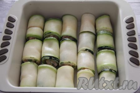 Завернуть начинку в несколько оборотов, формируя голубец из кабачка с начинкой. Аналогично сформировать все голубцы (у меня получилось 17 штук) и выложить их в жаропрочную форму.&nbsp;