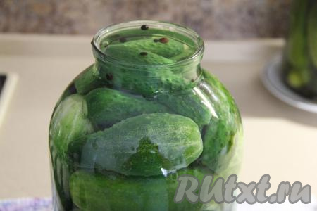 Залить огурцы горячим маринадом под самое горлышко банки. Накрыть банку блюдцем и оставить на 12 часов на столе на кухне.