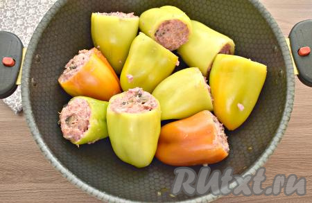 Болгарские перцы (желательно одинакового размера) очищаем от семян, промываем. Заполняем перцы начинкой из фарша, риса и грибов. У меня получилось 10 фаршированных перцев. Подготовленные перцы выкладываем в глубокую сковороду (или в кастрюлю).